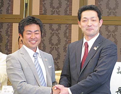 横山部長（左）と握手する山口次期部長