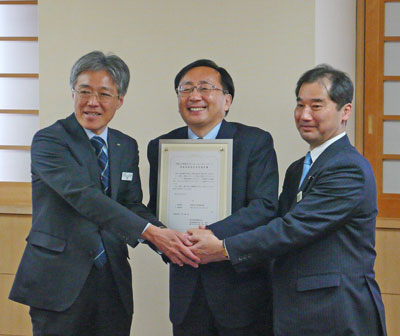 指定書を受けとり笑顔の三村知事(中央)