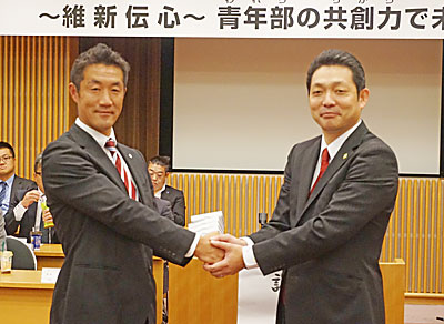 桑田次期部長（左）と山口部長が握手