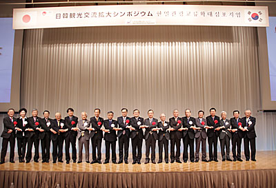 白リボンが日本、赤リボンが韓国の観光担当者