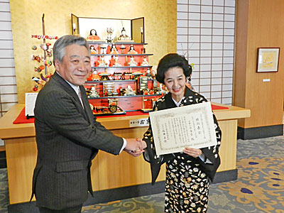 石井社長（左）から佐藤女将に表彰状手渡す